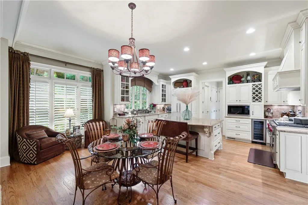 Dining space featuring a chandelier, crown molding, beverage cooler, light wood finished floors, and recessed lighting