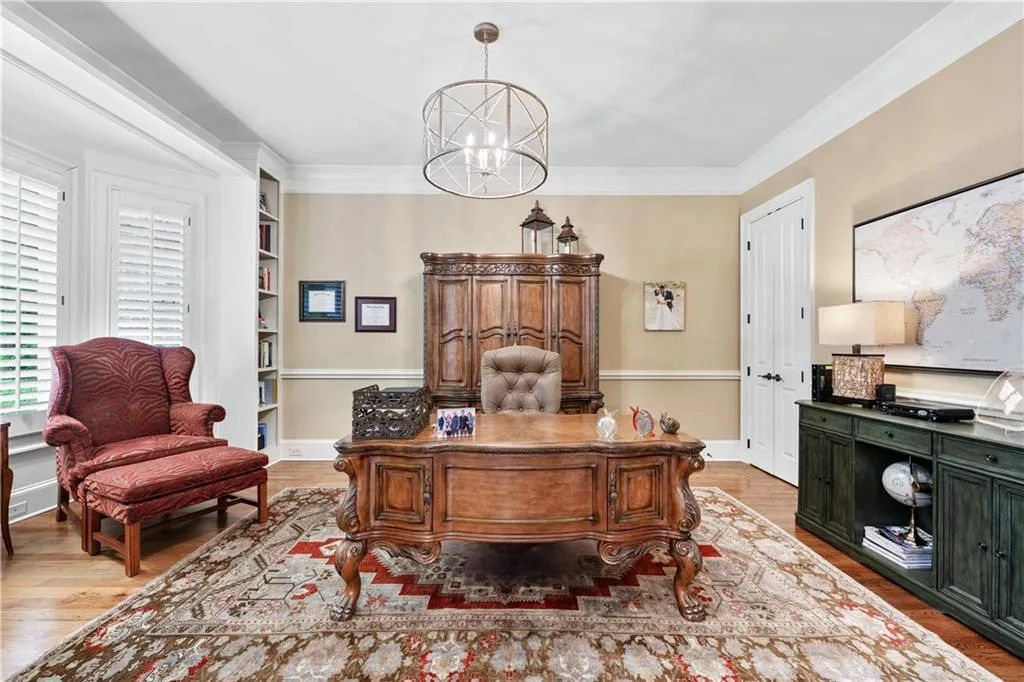 Office space featuring a chandelier, wood finished floors, ornamental molding, and built in features