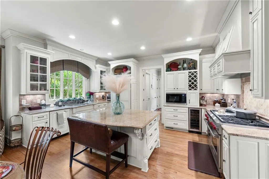 Kitchen featuring double oven range, tasteful backsplash, white cabinets, open shelves, and a center island