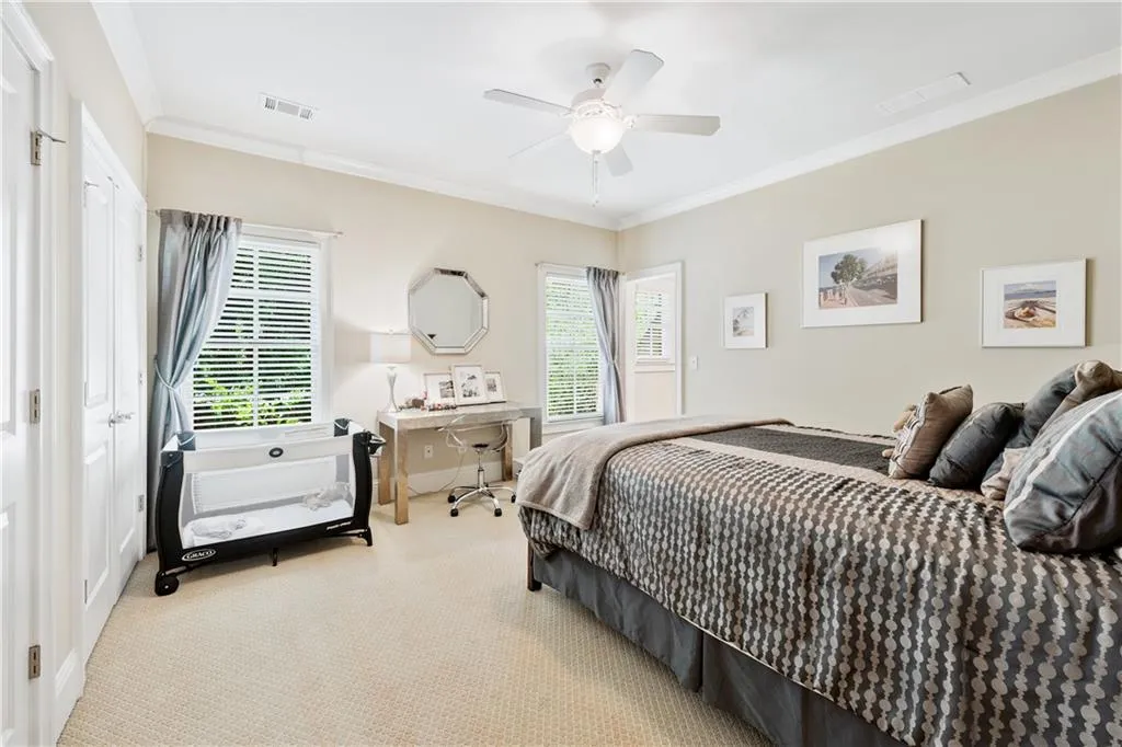 Bedroom with crown molding, carpet flooring, and a ceiling fan