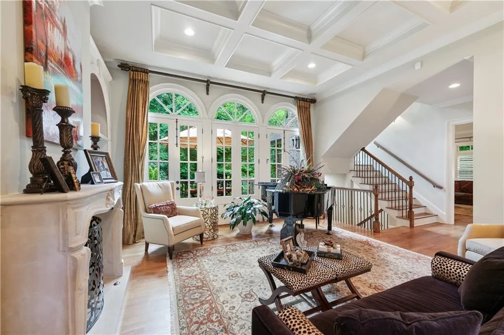 Living area featuring coffered ceiling, stairway, beamed ceiling, light wood-type flooring, and ornamental molding