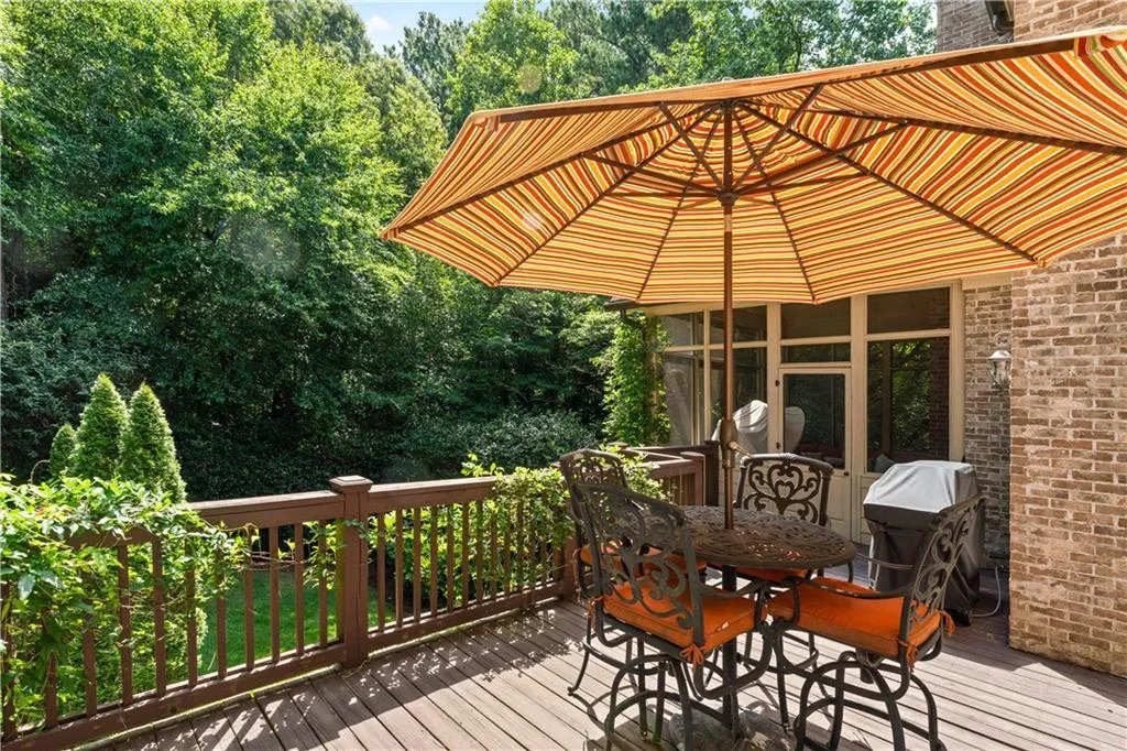 Wooden deck featuring a grill and outdoor dining area