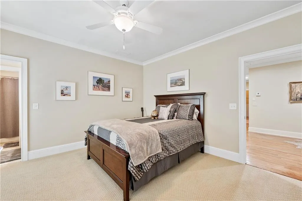 Bedroom with crown molding, ceiling fan, and light carpet