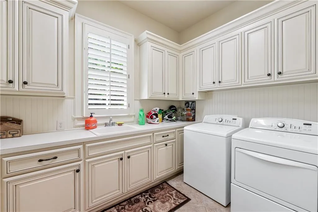 Laundry area with washer and clothes dryer, cabinet space, and light tile patterned flooring