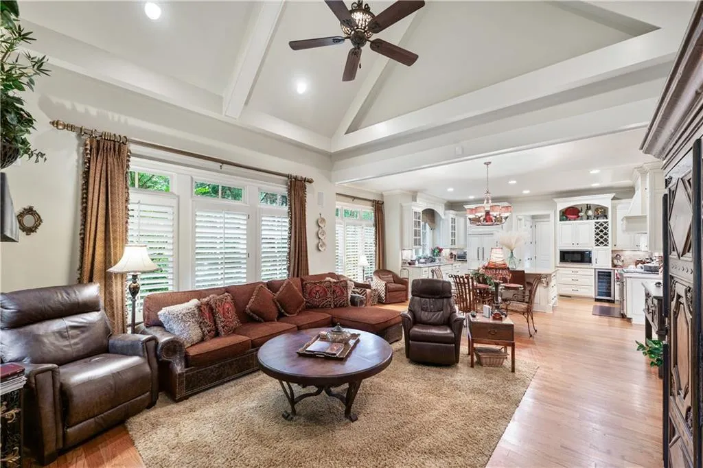 Living room with ceiling fan, beam ceiling, light wood-style floors, wine cooler, and recessed lighting