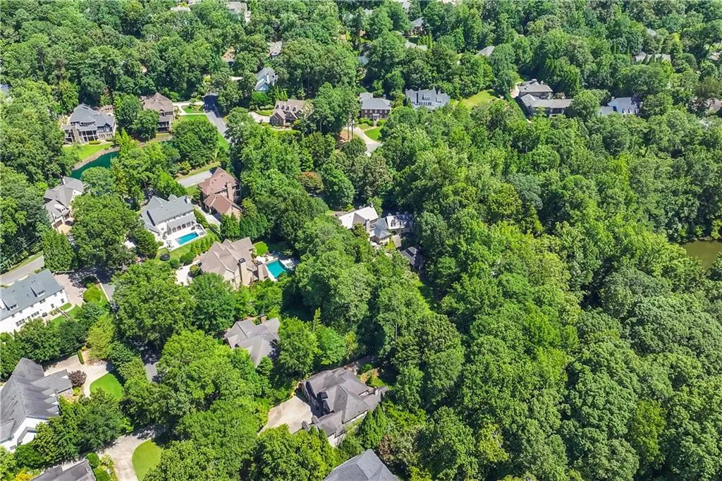 Aerial view of property and surrounding area featuring nearby suburban area