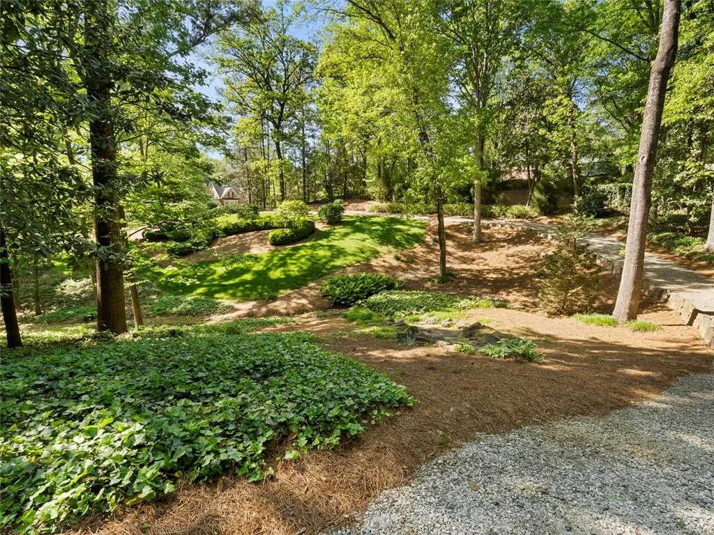 Long gravel drive up to main house.  This lot is deeded separately but included with the main house. Second gate, low maintenance.