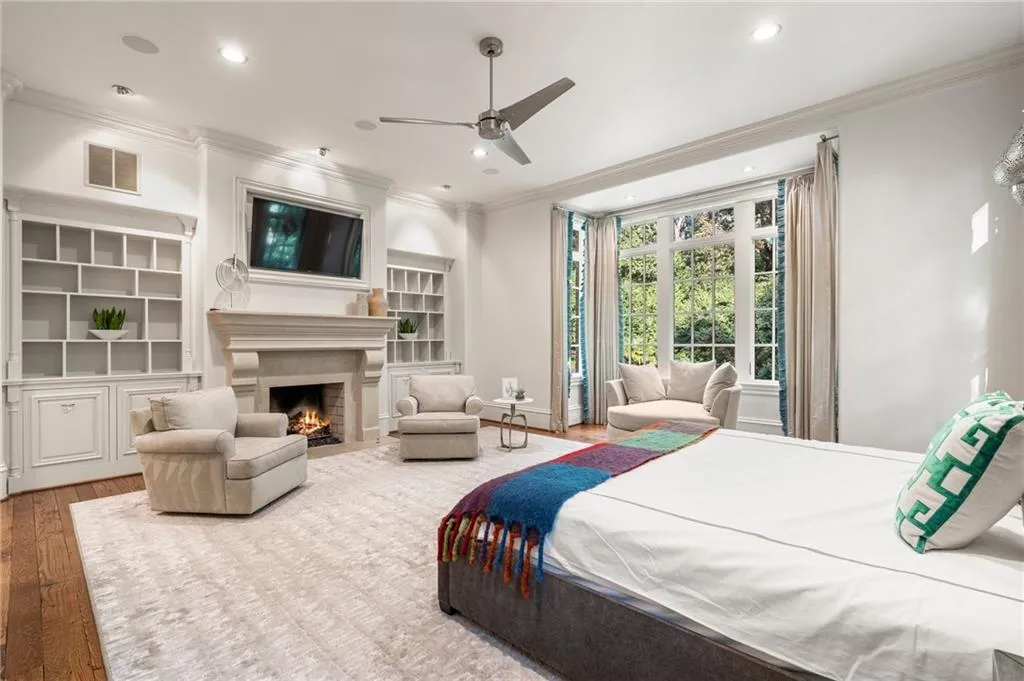 Bedroom with fireplace and pool views.