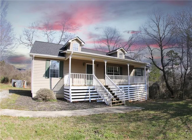 View of front of home featuring a porch, a front lawn, and a shingled roof