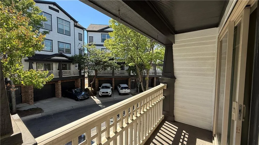 Balcony featuring painted wood railings and dark soffit, with a sliding glass exterior door