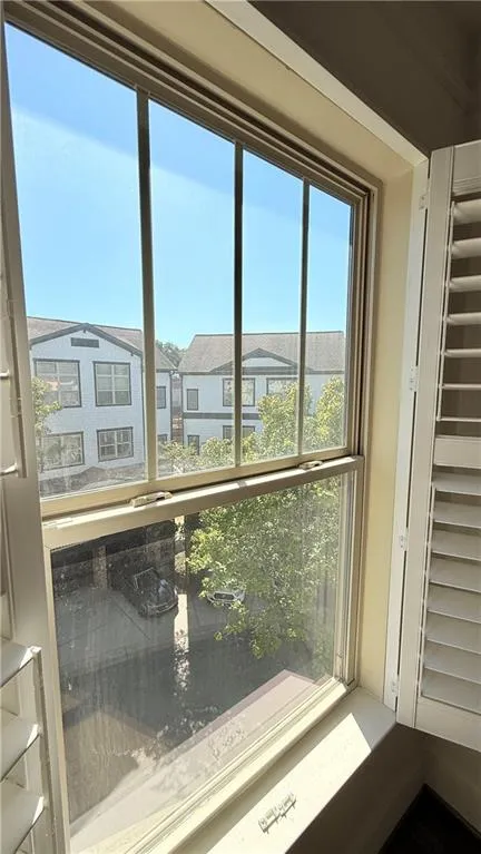 Double-hung window with white wooden shutters