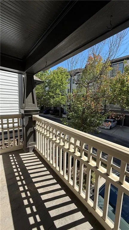 Balcony featuring a wooden railing, dark-stained ceiling, and structural support column