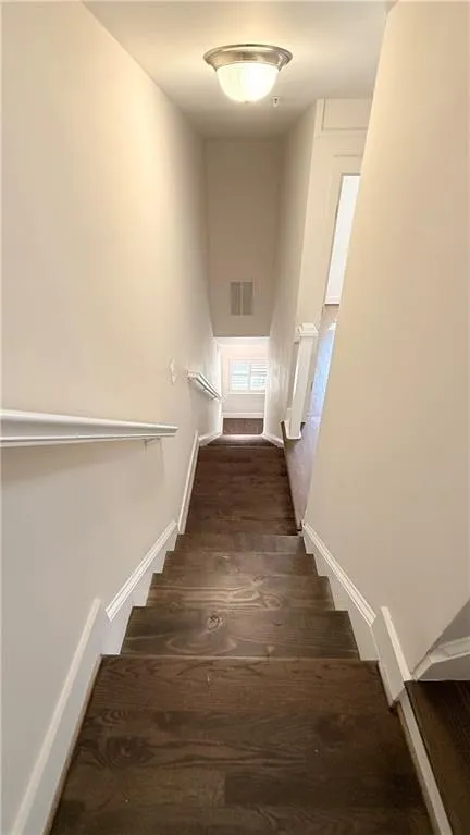 Recessed ceiling light fixture, wood-finish flooring, white wall trim, and light-toned wall paint