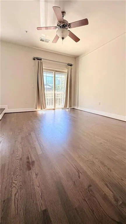 Wood-finish flooring throughout, ceiling fan with integrated lighting, and a sliding glass door