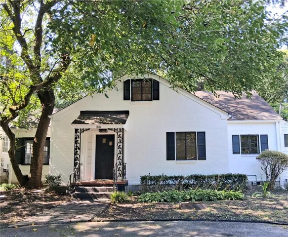 White-painted brick exterior with dark shutters and a covered entry