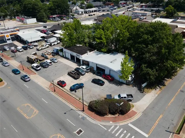Commercial property featuring a corner lot, multiple buildings, and ample paved parking