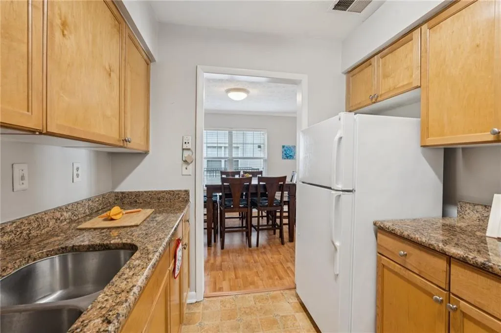 Kitchen featuring freestanding refrigerator and dark stone countertops