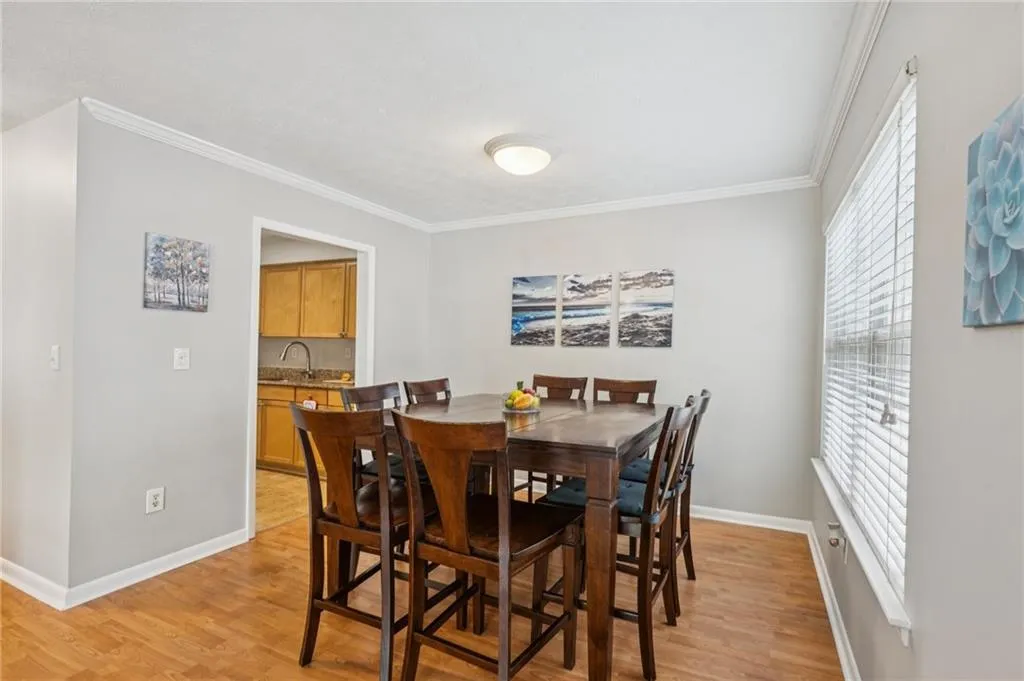 Dining area with ornamental molding and light wood finished floors