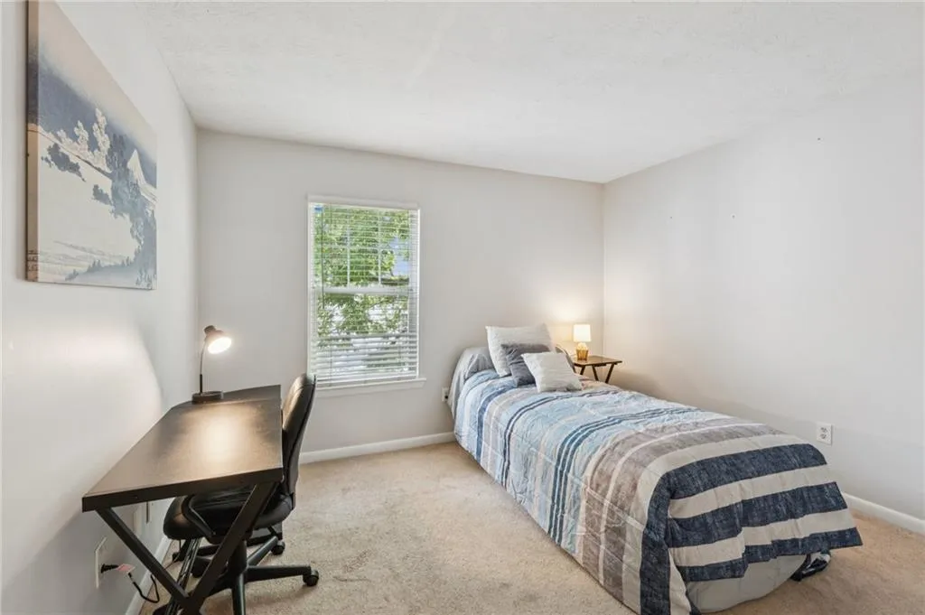 Carpeted bedroom featuring a desk and a textured ceiling