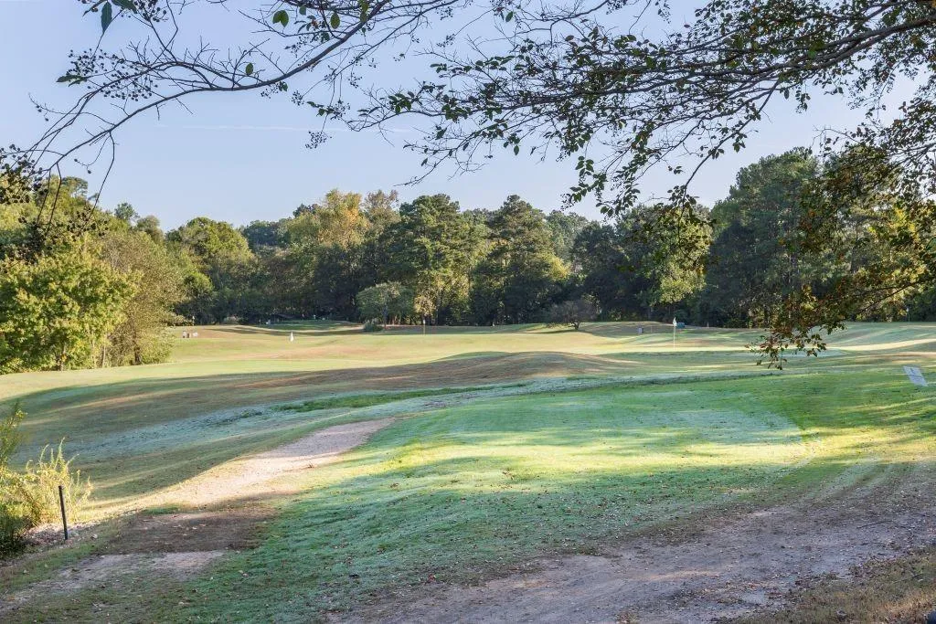 View of community with view of golf course, a yard, and view of scattered trees View of community with view of golf course, a yard, and view of scattered trees