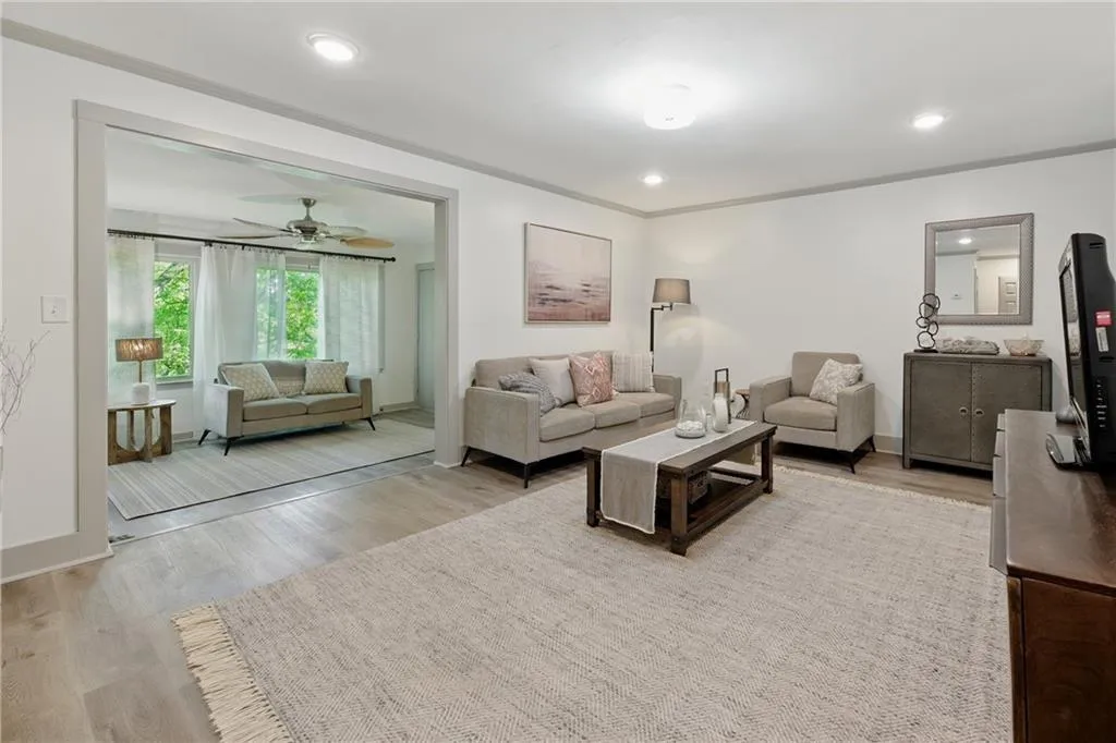 Living area featuring light wood-style floors, ornamental molding, recessed lighting, and a ceiling fan Living area featuring light wood-style floors, ornamental molding, recessed lighting, and a ceiling fan
