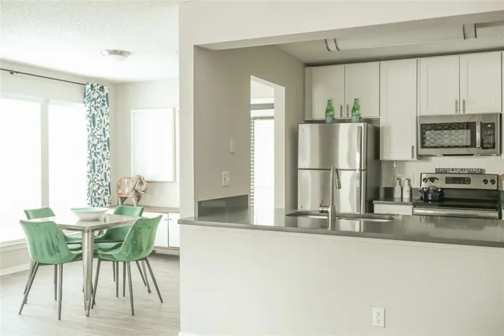 Kitchen featuring light hardwood / wood-style floors, tasteful backsplash, sink, white cabinets, and appliances with stainless steel finishes