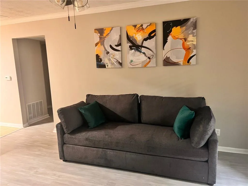 Living area featuring crown molding and light wood-style flooring