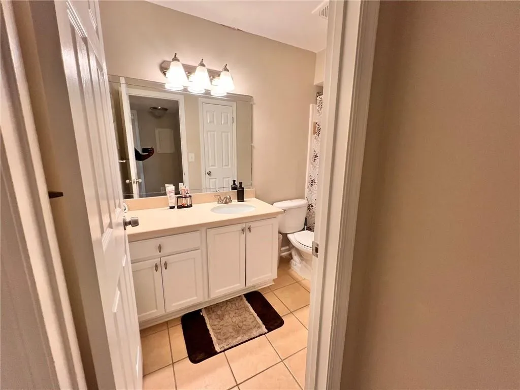 Full bath with light tile patterned floors and vanity