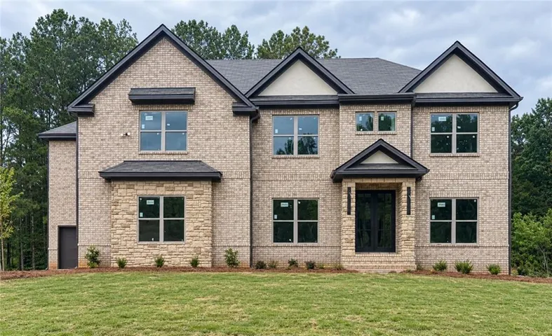 Striking brick Colonial featuring multiple gabled rooflines, black-trimmed windows with substantial glazing, and a welcoming covered entry