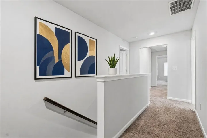 Carpeted hallway with painted walls and a white half-wall railing