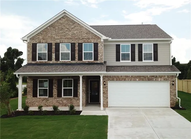 Two-story residence featuring a brick and siding exterior, covered front porch, attached two-car garage, and a concrete driveway