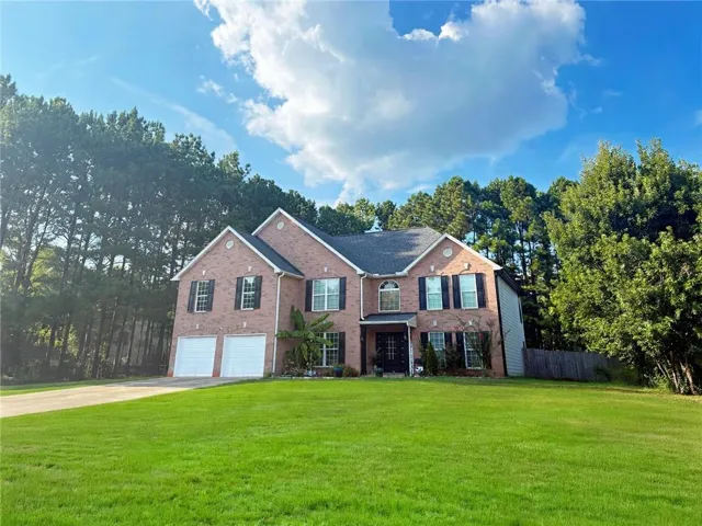 Brick exterior, two-car garage, multiple gables, front-facing windows with shutters, and a well-maintained lawn