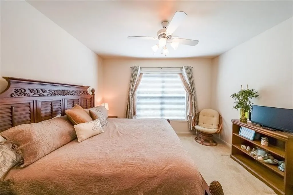 Bedroom with light carpet and ceiling fan