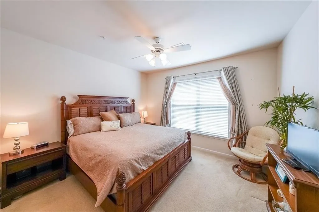 Bedroom with light carpet and a ceiling fan