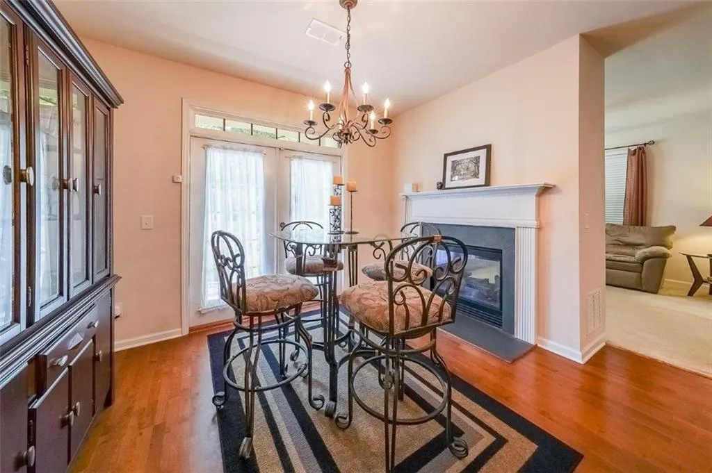 Dining room with light wood finished floors, a glass covered fireplace, and a chandelier