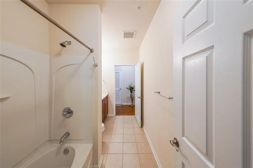 Full bathroom with tub / shower combination, light tile patterned flooring, and vanity
