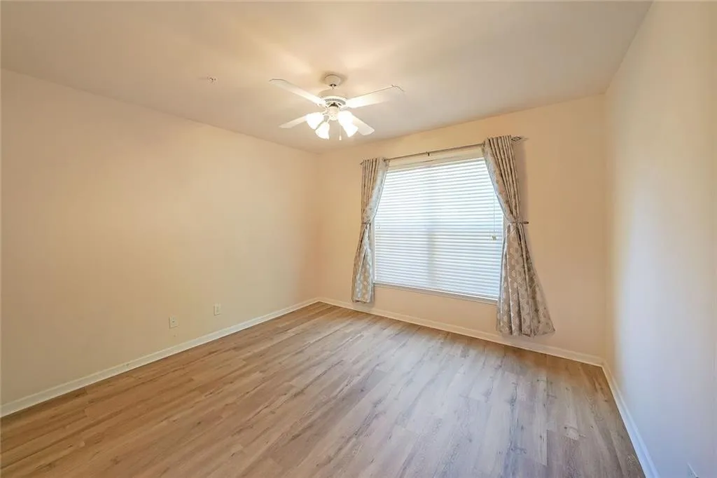 Spare room with light wood finished floors and a ceiling fan