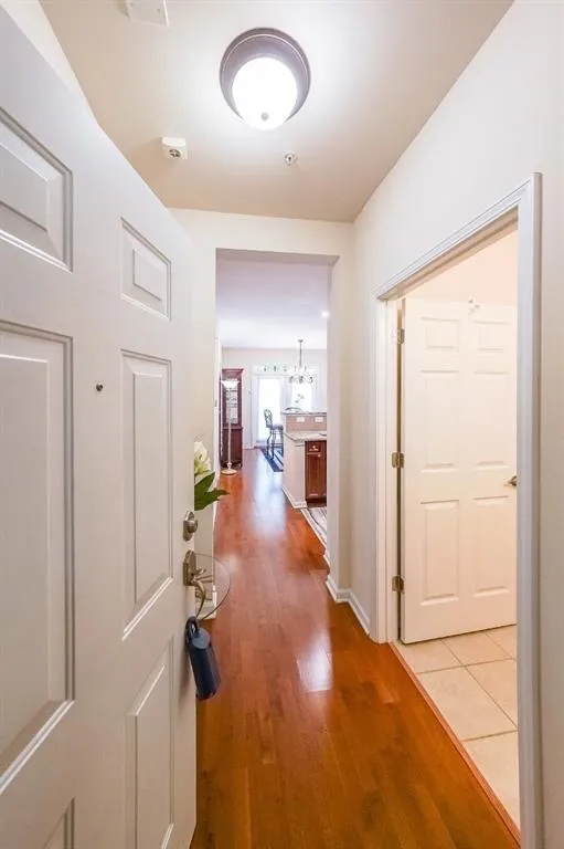 Hall with light wood-style flooring and a chandelier