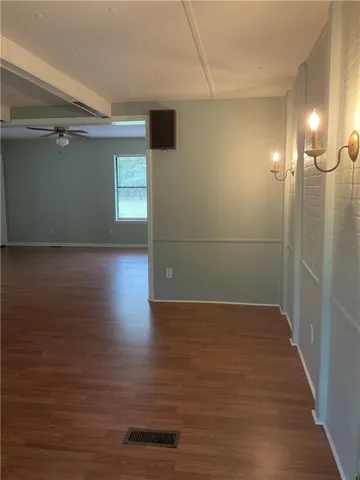 Unfurnished room with dark wood finished floors and a ceiling fan