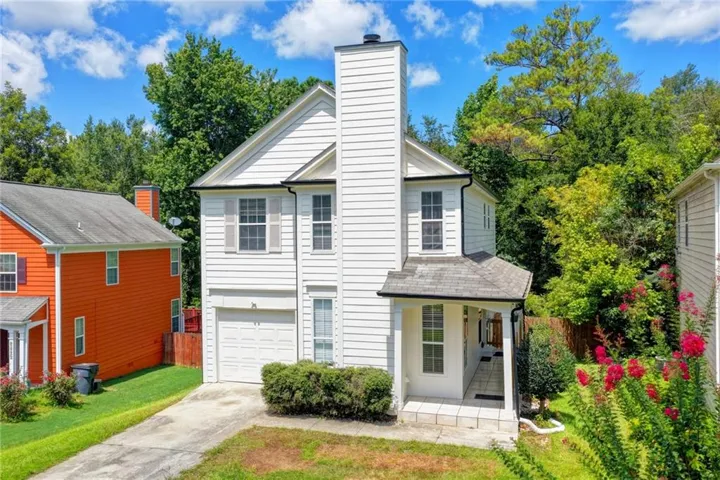 Two-story residence with white siding, an attached garage, and a covered entry porch