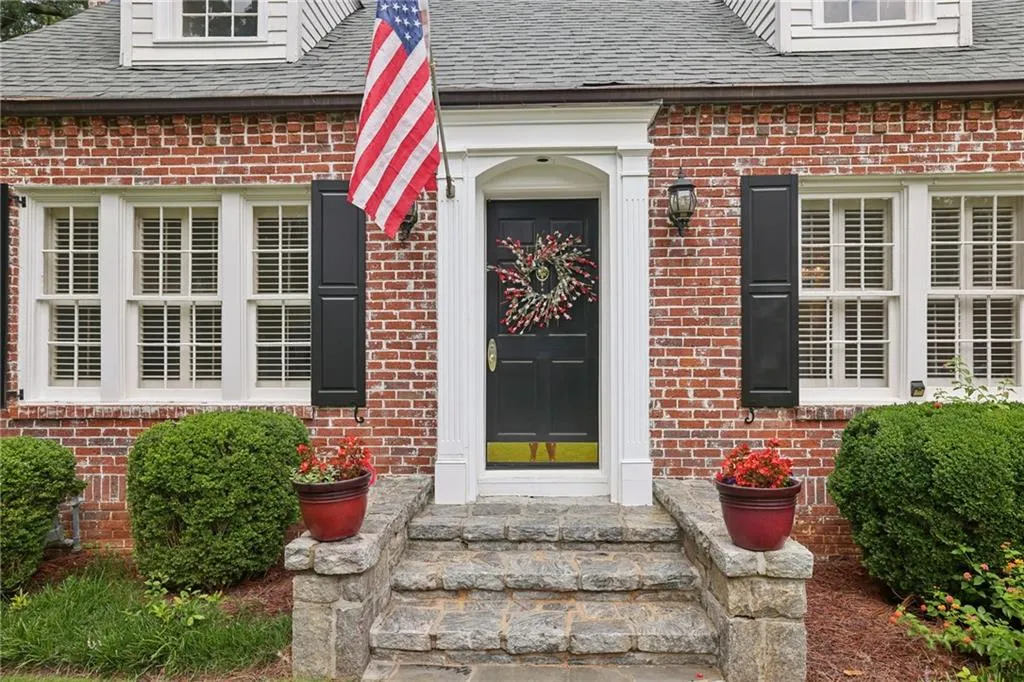 Red brick exterior with white trim windows and black shutters
