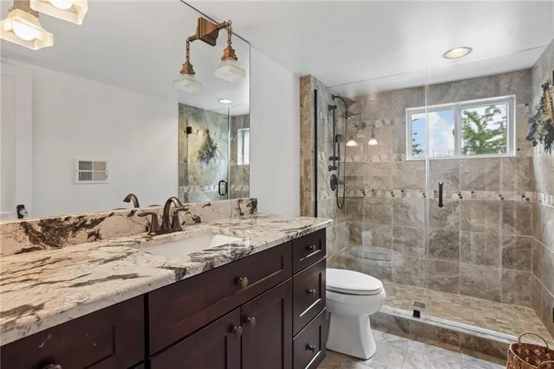 Dark wood-finish vanity with dual integrated sinks and a patterned countertop