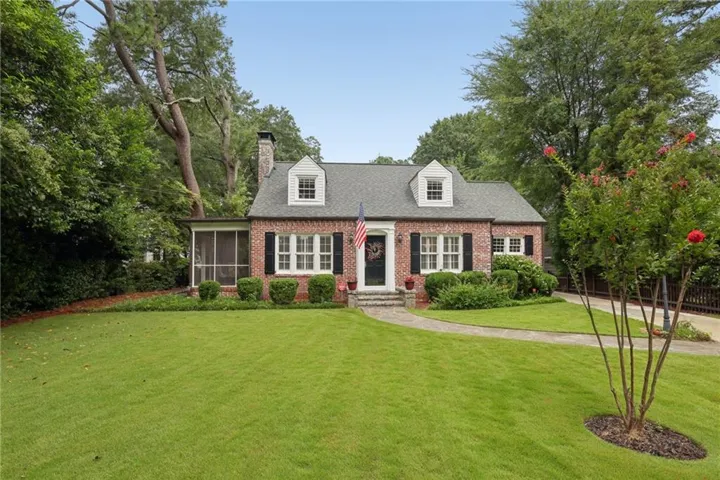 Brick exterior with dormer windows, a screened porch, and a stone walkway