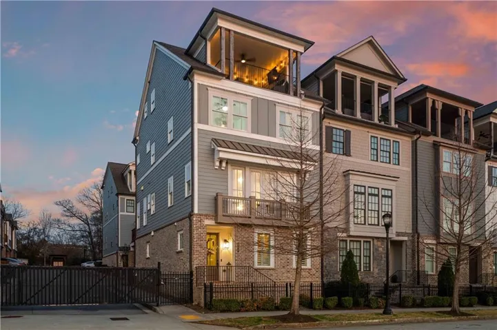 Multi-story facade featuring brick and siding, a private balcony, an elevated patio, and a street-level entrance