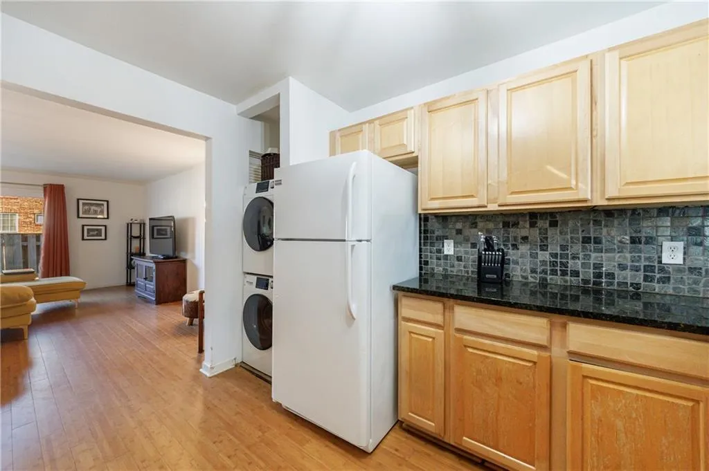 Kitchen featuring freestanding refrigerator, tasteful backsplash, light wood-style floors, and light brown cabinetry