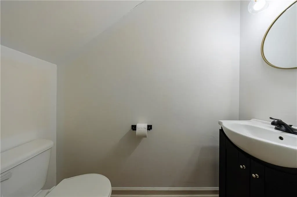 Half bathroom featuring vanity and lofted ceiling