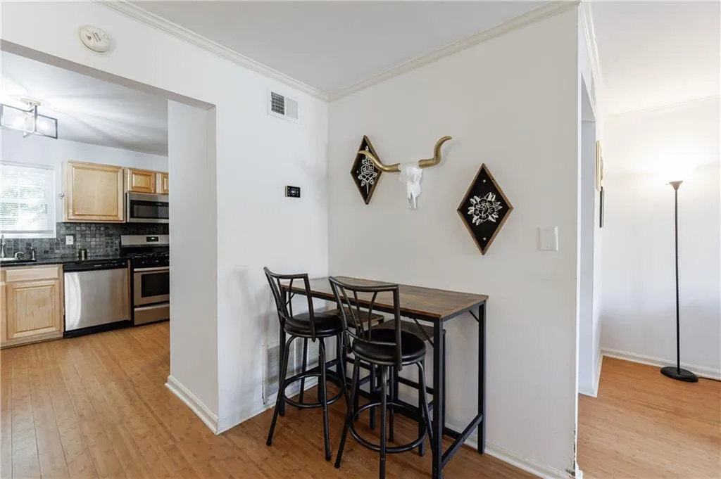 Dining room with light wood-style floors and crown molding