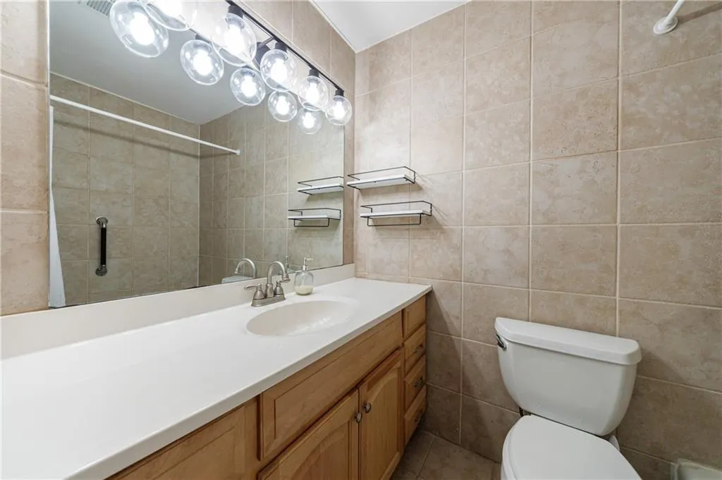 Bathroom with vanity, tile walls, and a shower