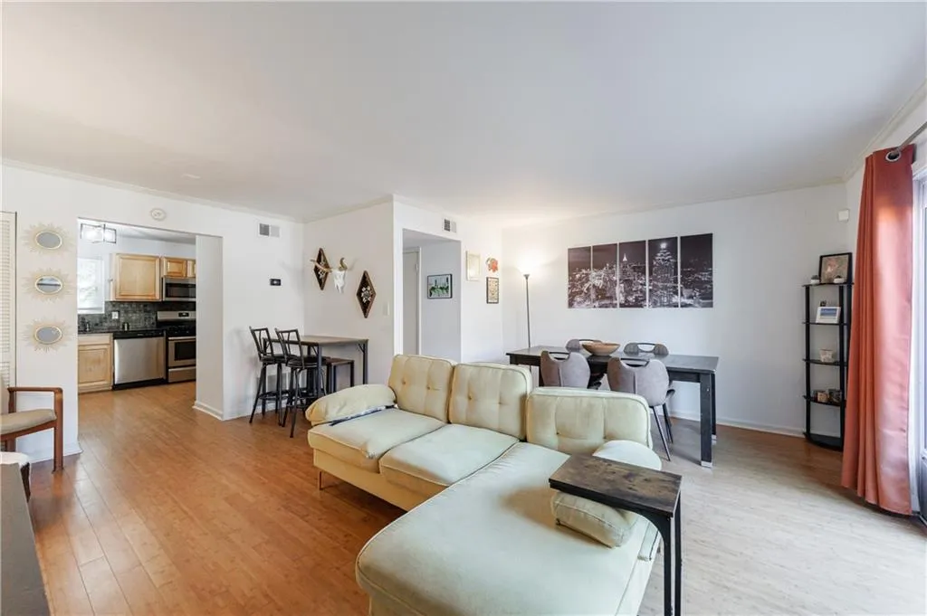 Living room featuring light wood-type flooring and crown molding