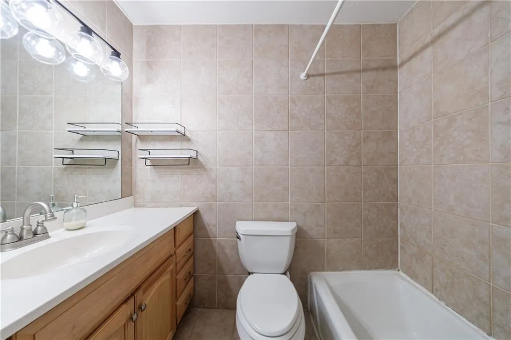 Bathroom with vanity, tile walls, and tub / shower combination